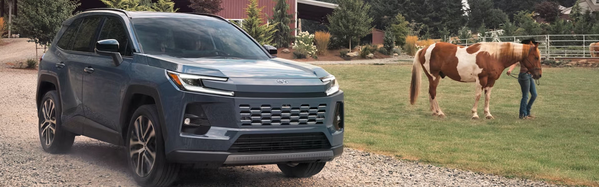 2026 Toyota RAV4 compact SUV on a rural road, showcasing dependable performance, modern design, fuel efficiency, advanced safety features, and versatile capability for daily driving.